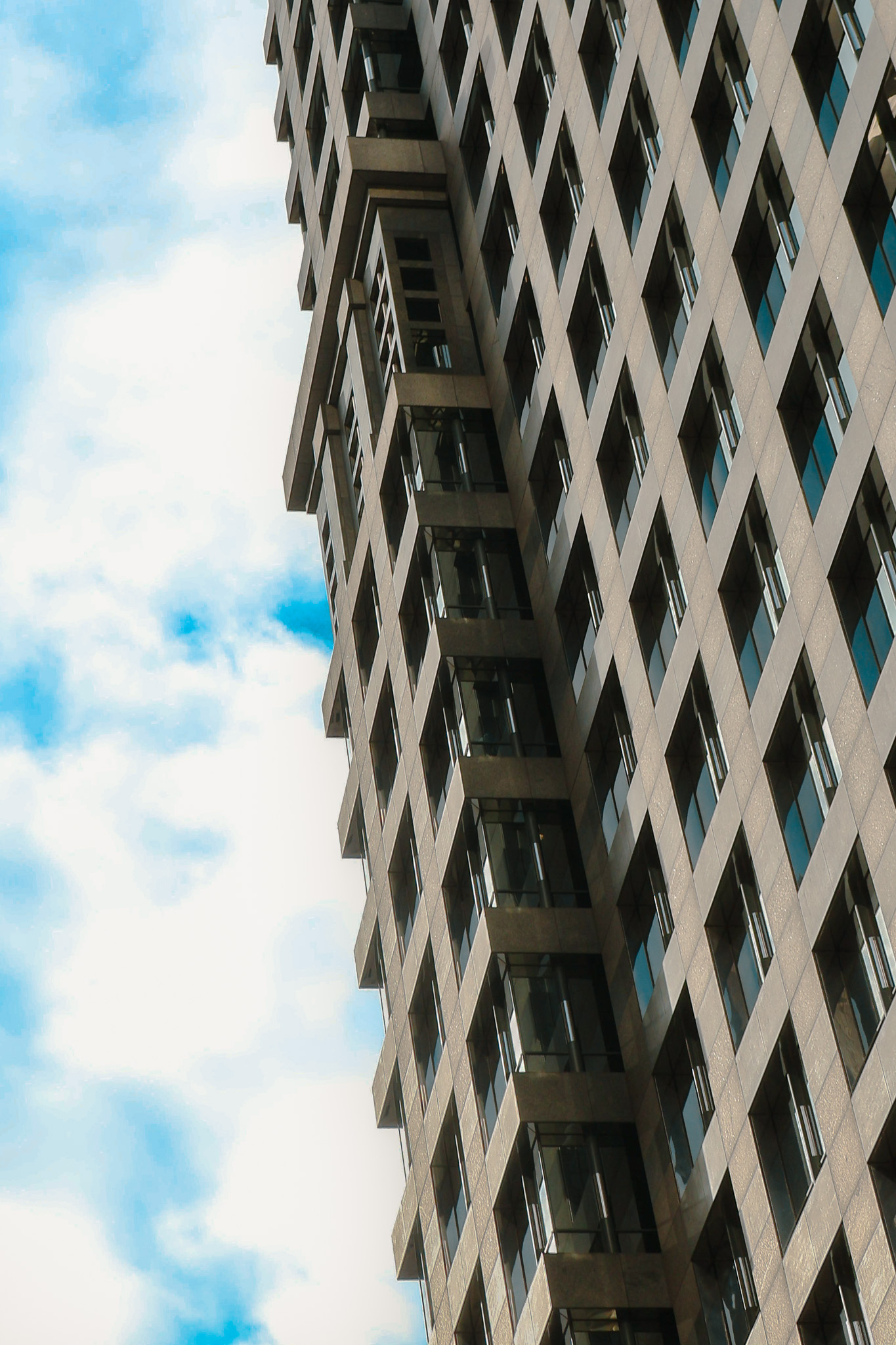 Geometric building facade viewed from below in grayscale